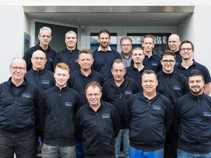 Mitarbeiterteam des Unternehmens vor dem Firmeneingang