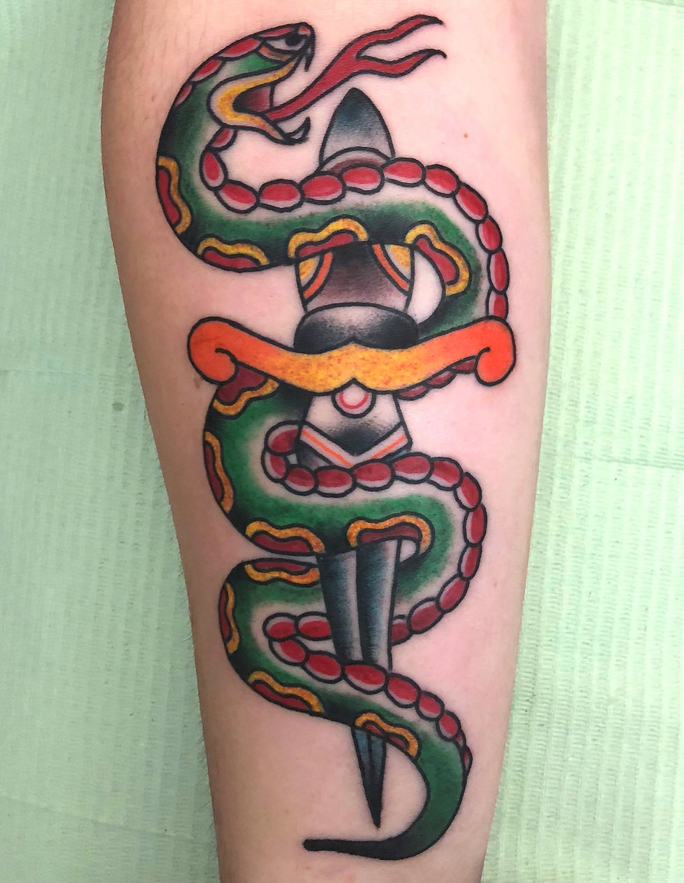 Traditional snake and dagger tattoo by Tommy Borboa