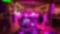 Large group of people arm in arm positioned around a dance floor in a circle. illuminated with disco lighting