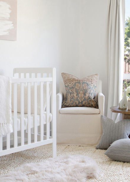 soft neutral nursery corner with white crib and textured throw blanket