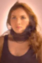 Tal Anderson, wrapped in sheer black fabric. Soft lighting enhances her emotion; background is plain.