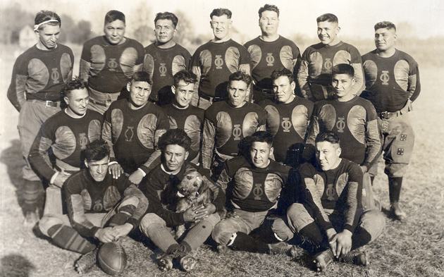 The Oorang Indians, including a King Oorang Airedale (mascot) in the front row. Coach Jim Thorpe is in back row (middle.)