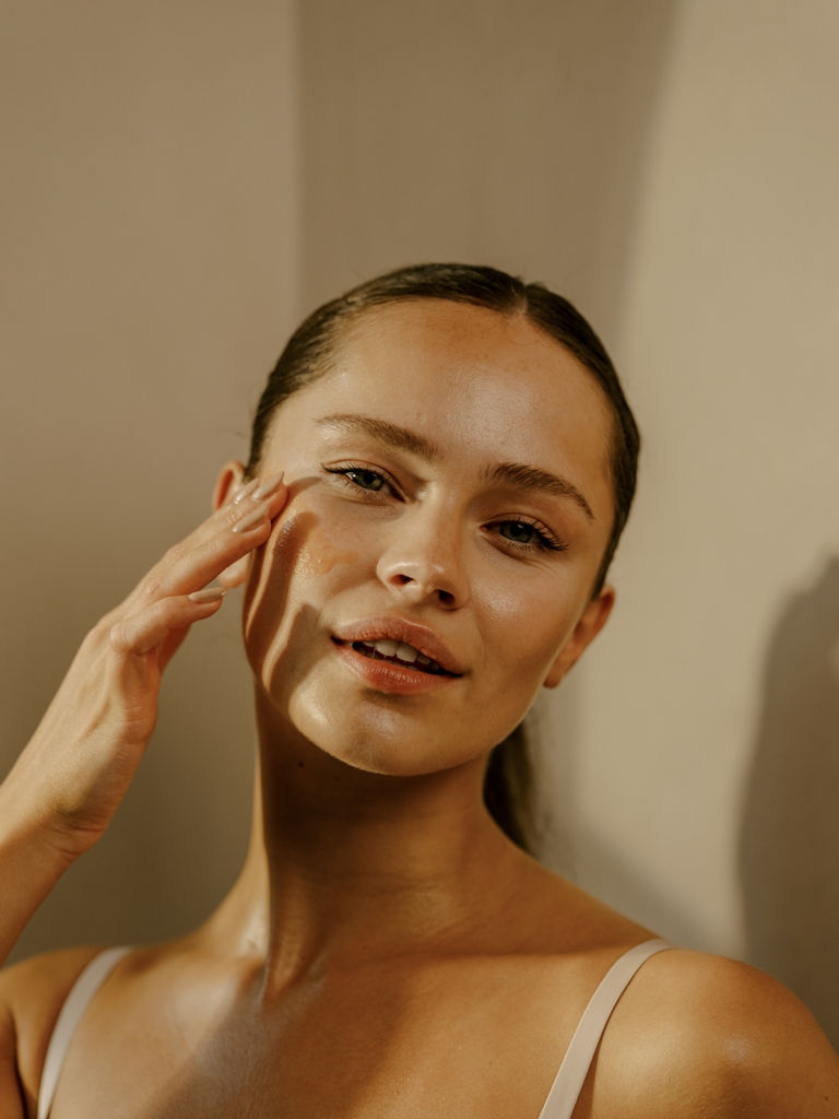 Woman applying natural face cream, highlighting Primally Pure’s clean skincare routine for healthy, glowing skin.