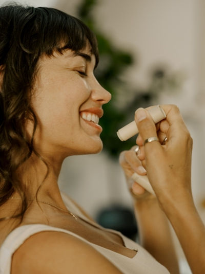Woman applying natural deodorant stick, showcasing Primally Pure’s clean, aluminum-free skincare routine.