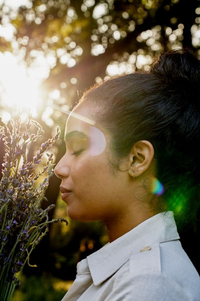 Woman enjoying sunlight outdoors, reflecting natural ingredients and holistic skincare values from Primally Pure.