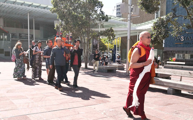 Ven. Lhagon Rinpoche of Dhargyey Buddhist Centre leading the way for Maitreya's palanquin being carried by lay people during the procession in Aotea Square at the Great Prayer Festival.