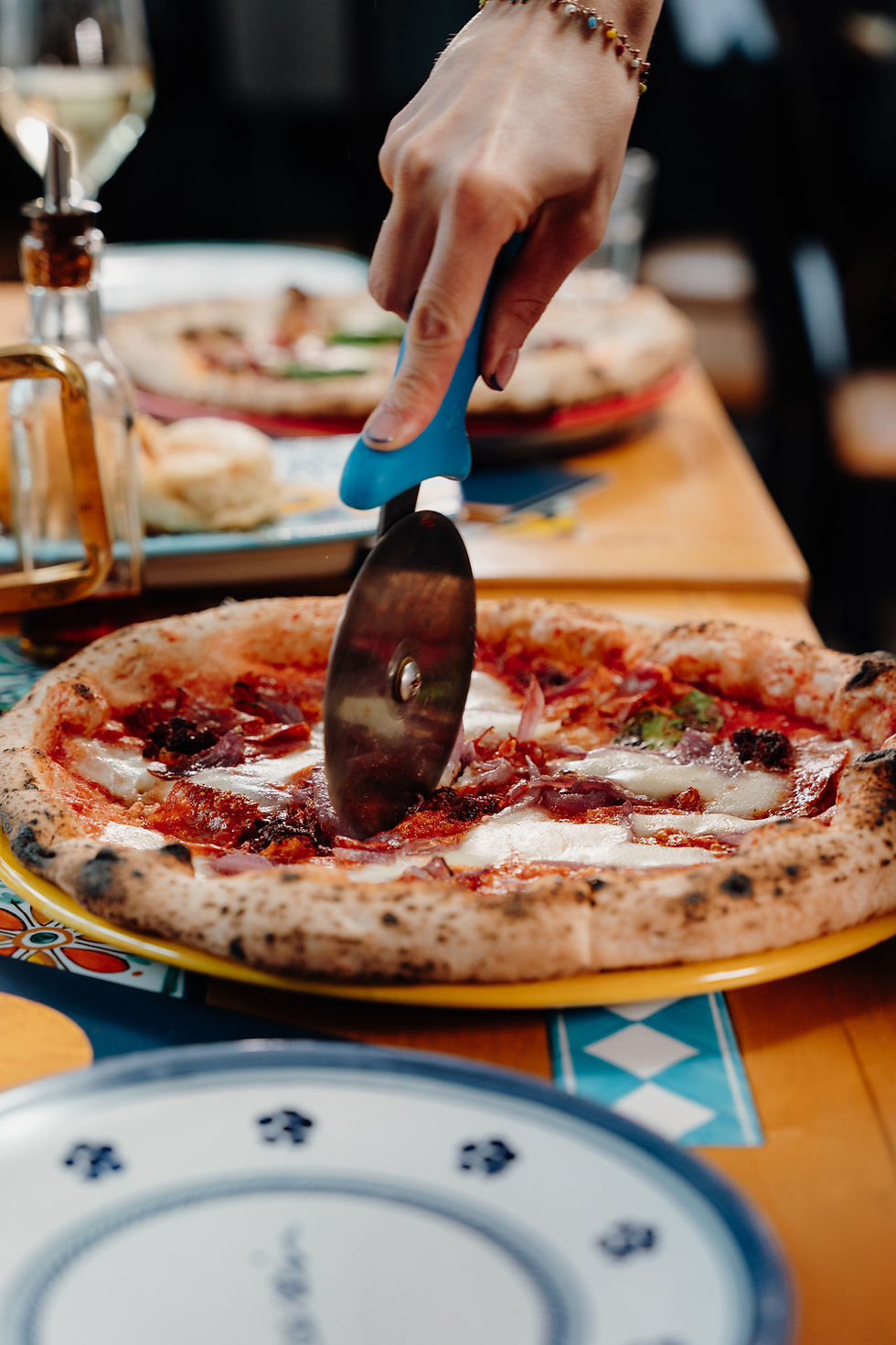 Cutting wood-fired Neapolitan pizza at Italian restaurant in York near me