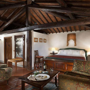 Camera in stile rustico toscano con pavimenti in cotto e travi a vista Gaiole in Chianti