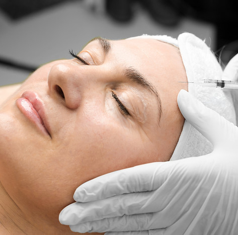 Young caucasian woman getting botox cosmetic injection in a forehead. Beautiful woman gets