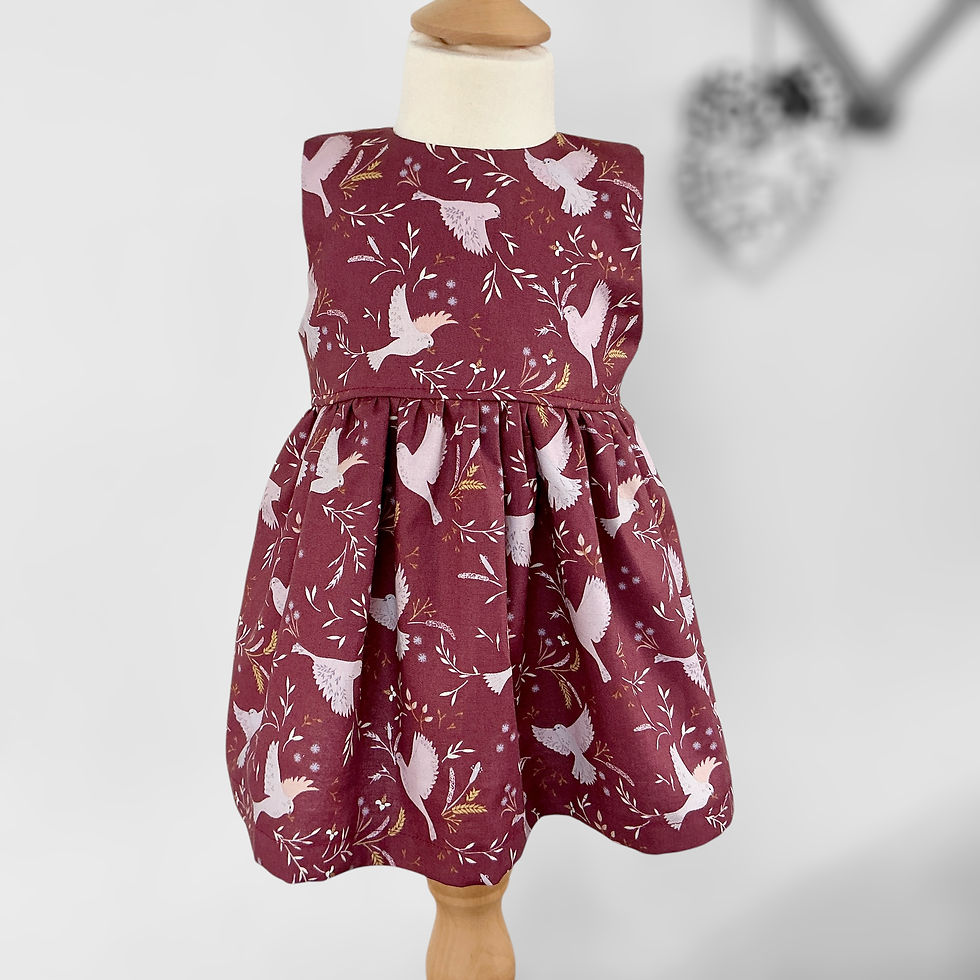 Girls Sleeveless dress in muted wine cotton scattered with doves on a mannequin