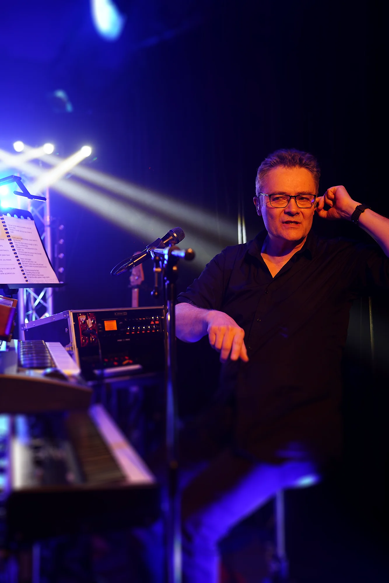 Claviériste et chanteur de Parallel Project sur scène, ajustant son oreillette avant le final du Tribute Fest 2025.