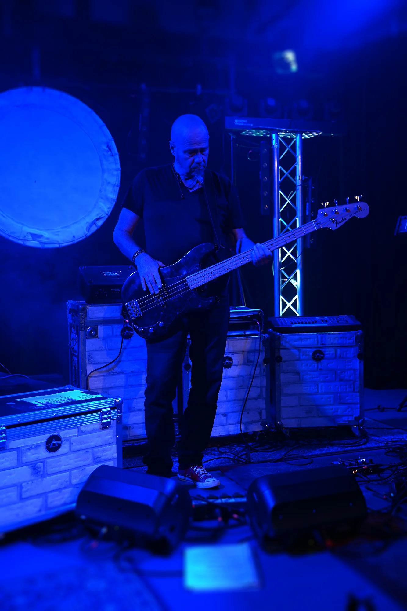 Bassiste de Parallel Project en concert sous éclairage bleu, ambiance immersive Pink Floyd à la Grange aux Dîmes.