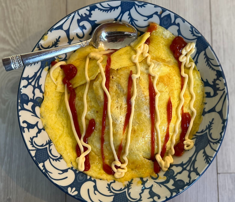 Japanese Omurice in a bowl with ketchup, kewpie mayo, and a sppon