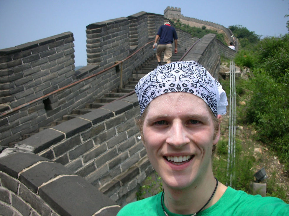Me standing on the Great Wall of China, sweating while wearing a bandana..