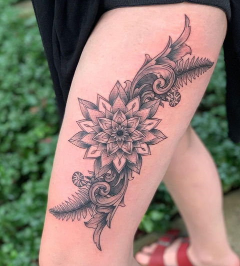 Flower and leaf botanical tattoo with sharp lines to accentuate the differences in tone. 
