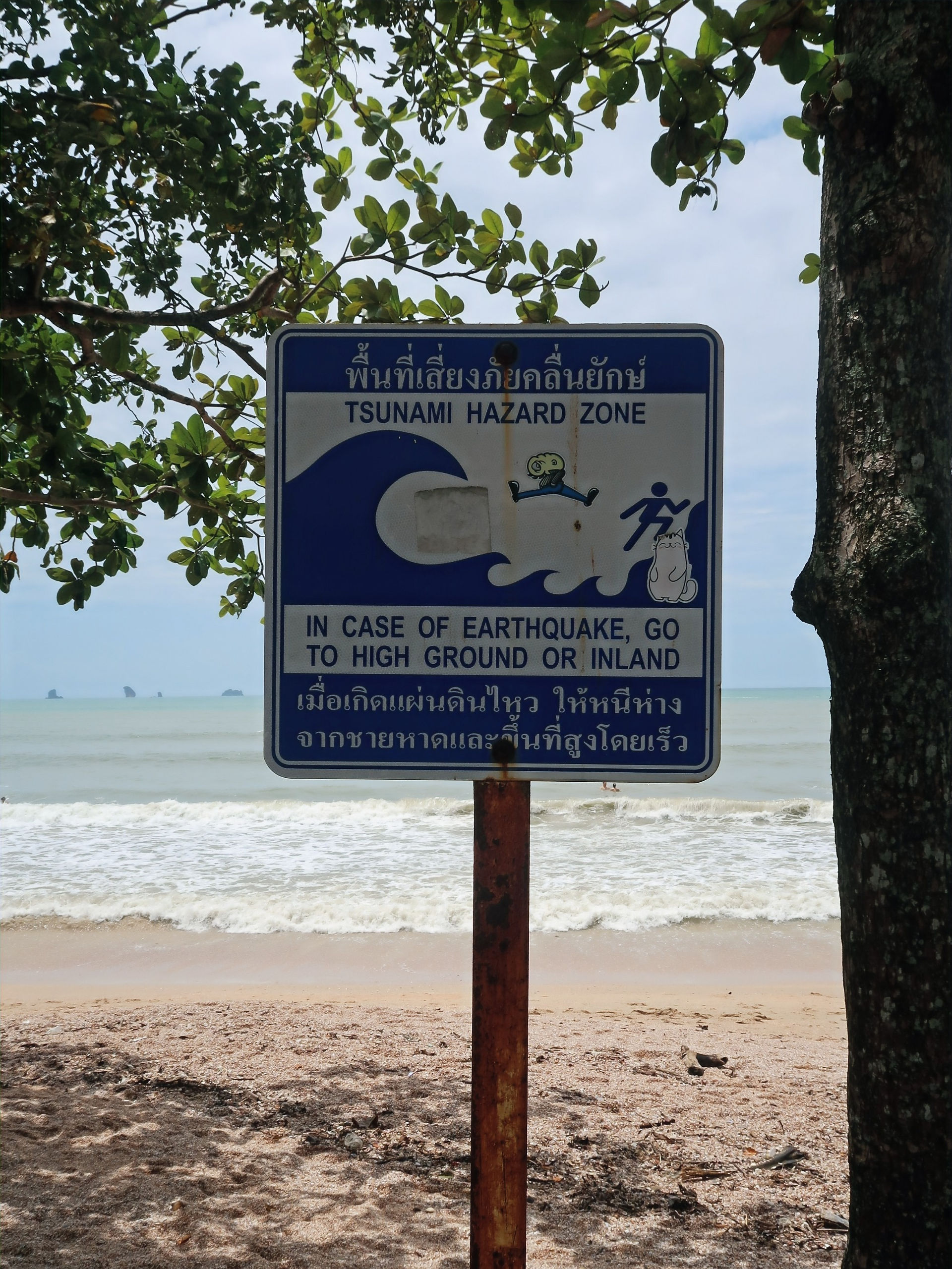 Placa a alertar que estamos numa zona de risco de tsunami na praia de Krabi, Tailândia