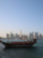 Dhow, o barco típico para a apanha da pérola e o skyline de West Bay, Doha, Catar