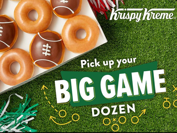 Box of donuts with football designs on green turf. Text: Krispy Kreme, Pick up your Big Game Dozen. Festive and playful mood.