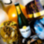 Ring in the New Year with Ivanhoe Park Brewing Co. and Ivanhoe Park Lager House - two locations, double the fun. New Year's celebration items: a champagne bottle labeled "BALL DROP", party hat, and decorations reading "HAPPY NEW YEAR!" in gold and black.