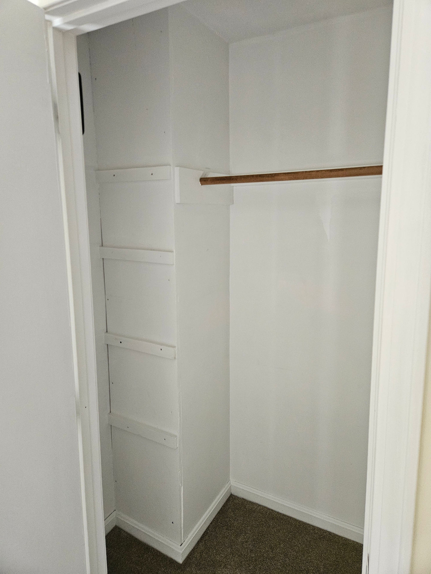 Closet with freshly painted white walls and shelf supports, showcasing a neat and updated appearance. Repainting by T&B Paint Pros LLC, Flagler County Painter.