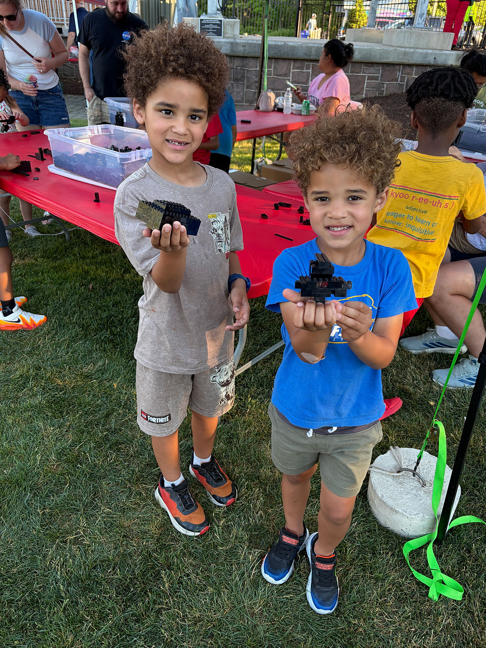 In the LEGO® Black Brick Play Zone, children could create whatever they pleased and take their creations home with them. Presenting their finest are, from left, Maverick, 7, and Cayden, 5, Johnson from Simsbury.