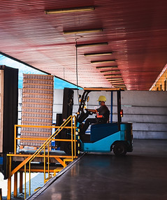 A truck reversed with door open and a forklift pulling out a pallet