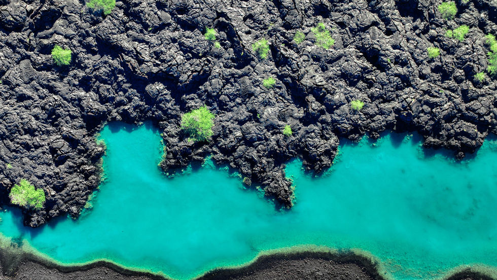 volcanic glacier blue waters sandwiched between black sand beaches and rock lava formations