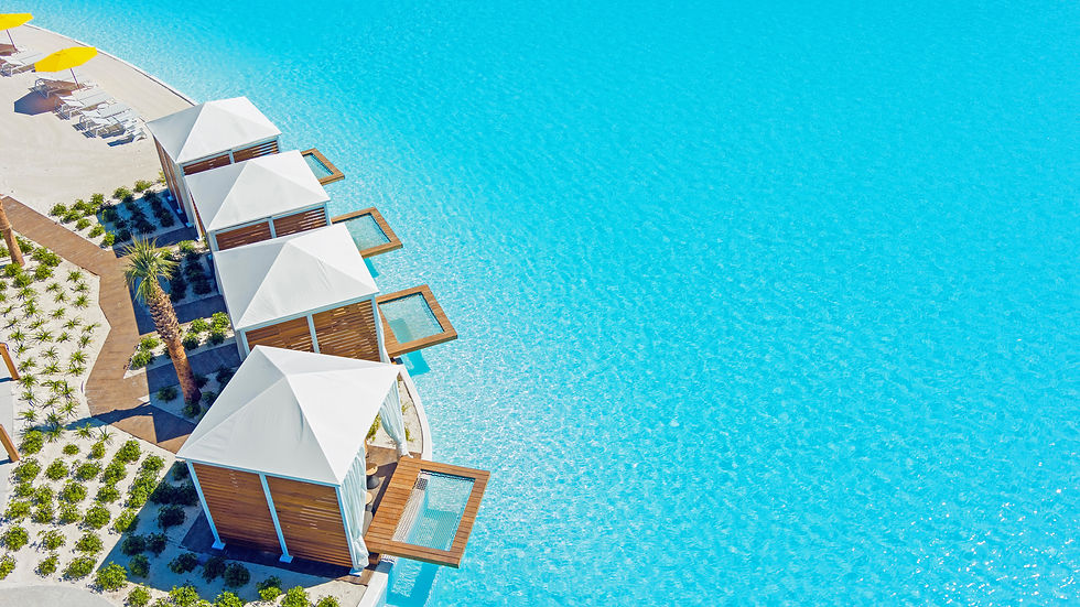 4 luxury cabanas sitting next to the vibrant blue pool waters with hammocks that cantilever over in to the pool