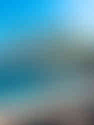 man walking along a white sand beach with turquoise blue water and palm trees standing in the background