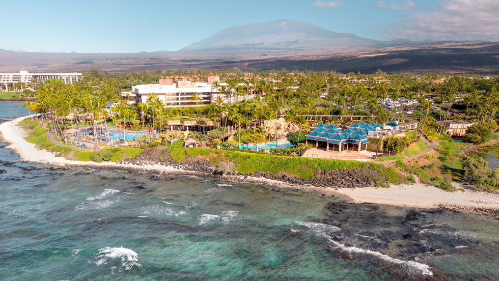 hotel and pools next to the beach with crashing waves