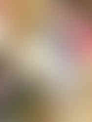 woman holding a baby in a red shit showing him a blue container of bubbles and other gifts from a cart