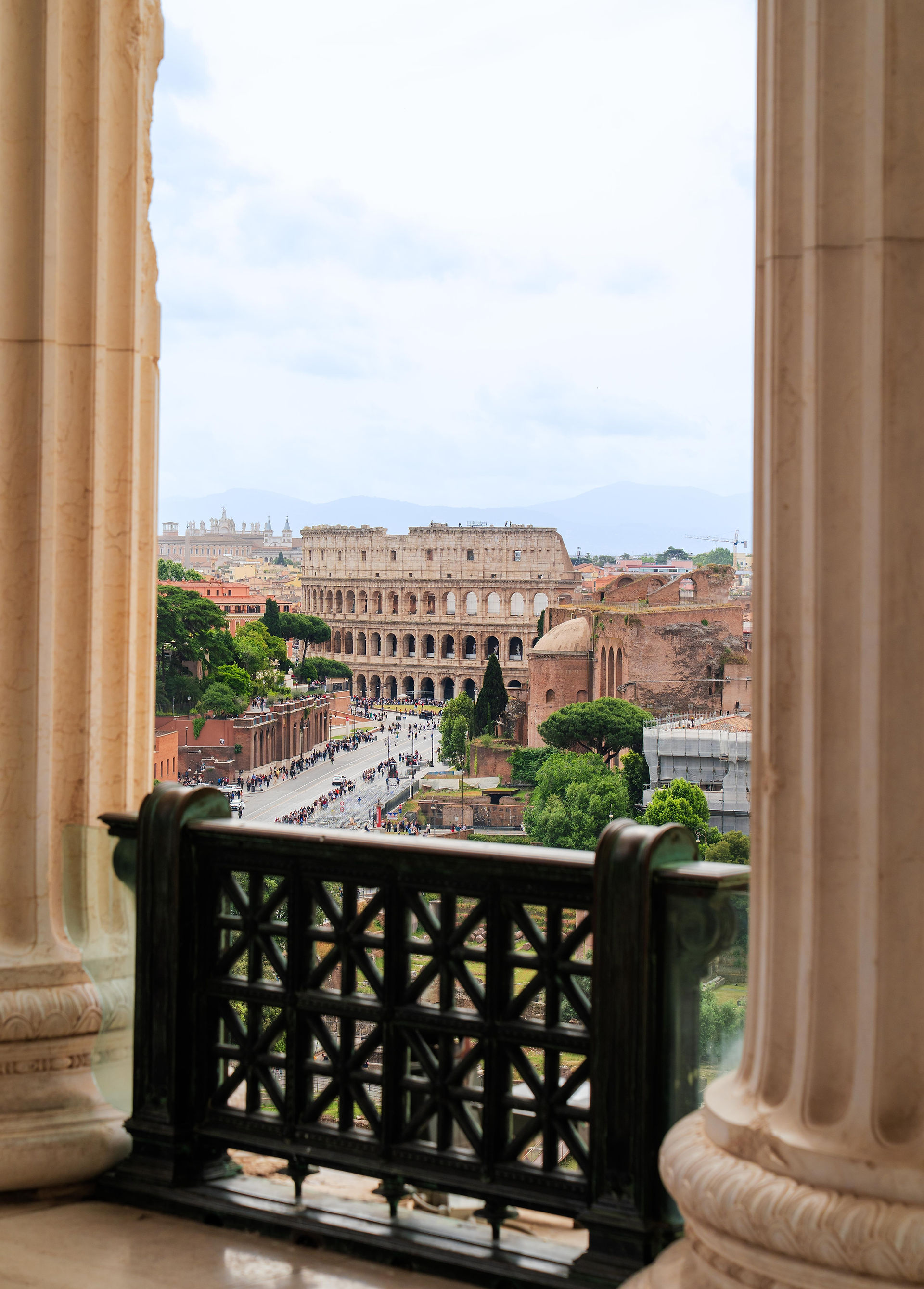 the Roman Colosseum framed by the white column stone towers 