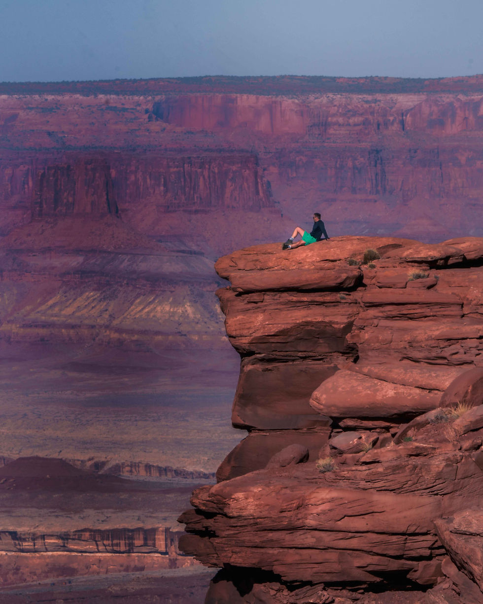 Man sitting on the ledge of the cliff at Canyonlands National Park
