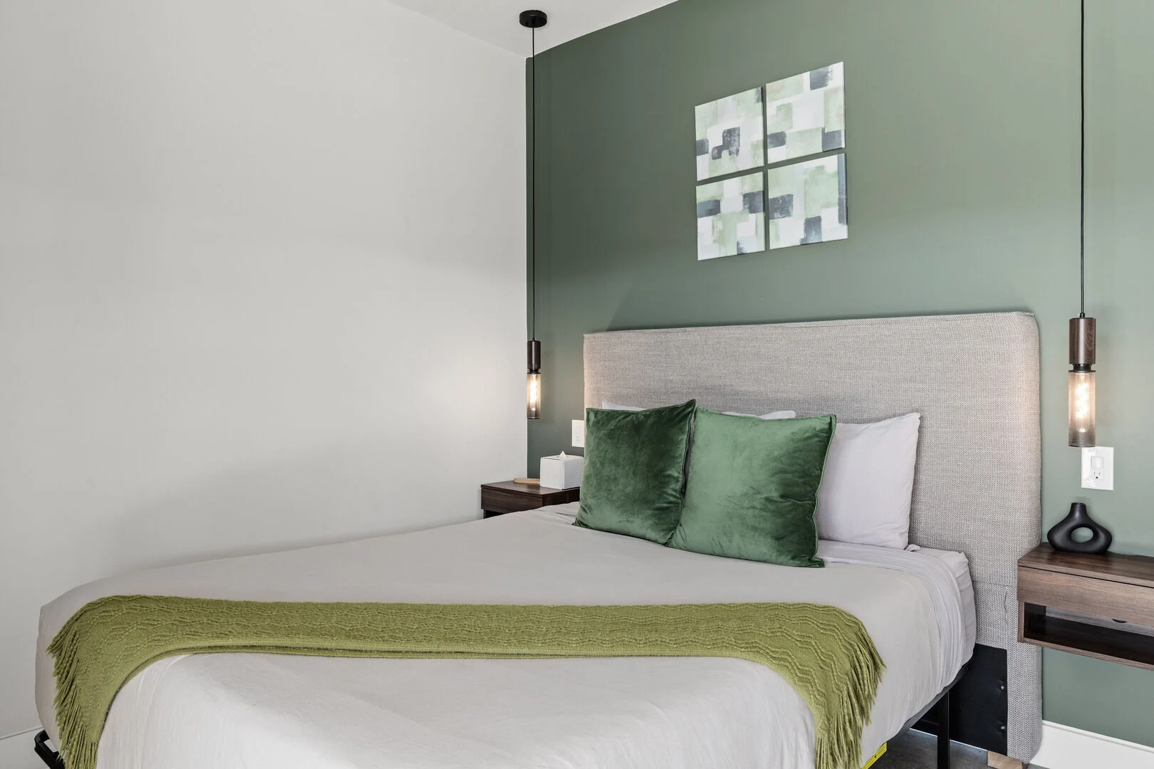 green accent blankets and pillows with a green wall in a guest room at a Joshua Tree vacation rental 