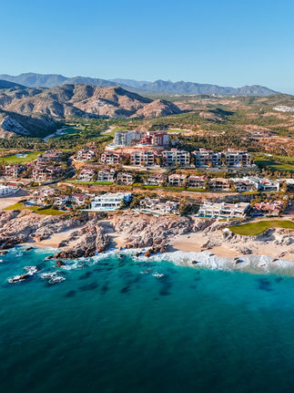 aerial view of the neighboring private homes on the golf course and hillside overlooking the beach