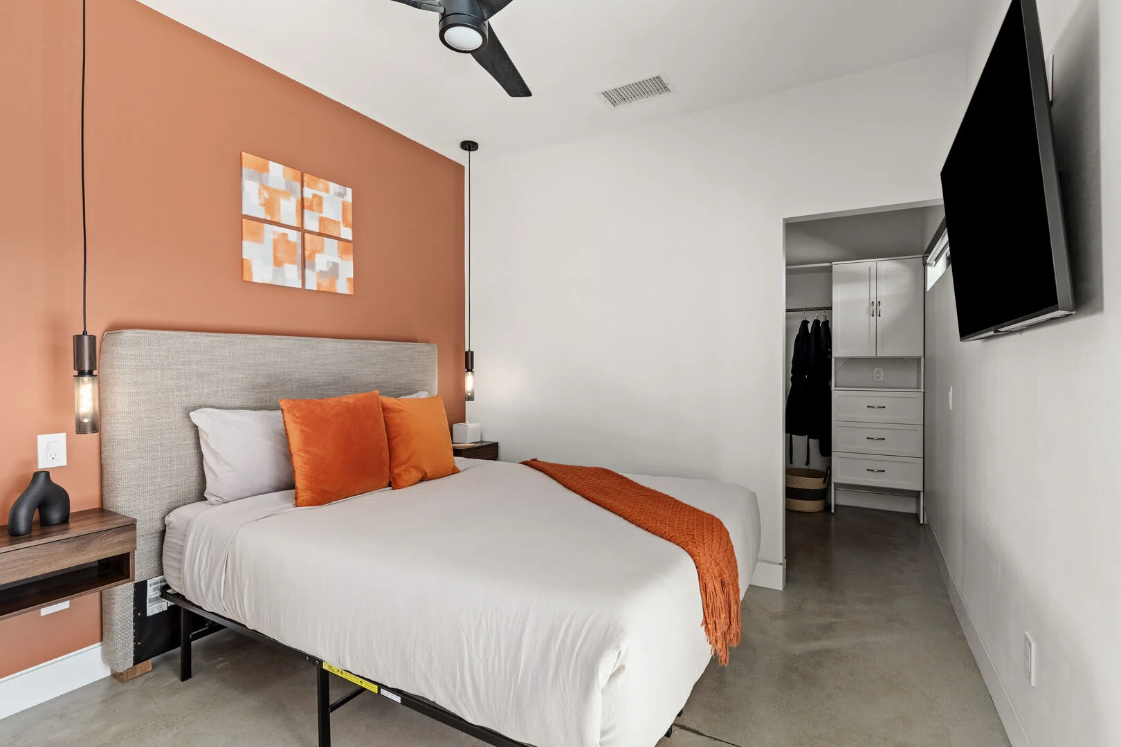 orange accents in a guest bedroom with a tv on the wall in a vacation rental property in the desert 