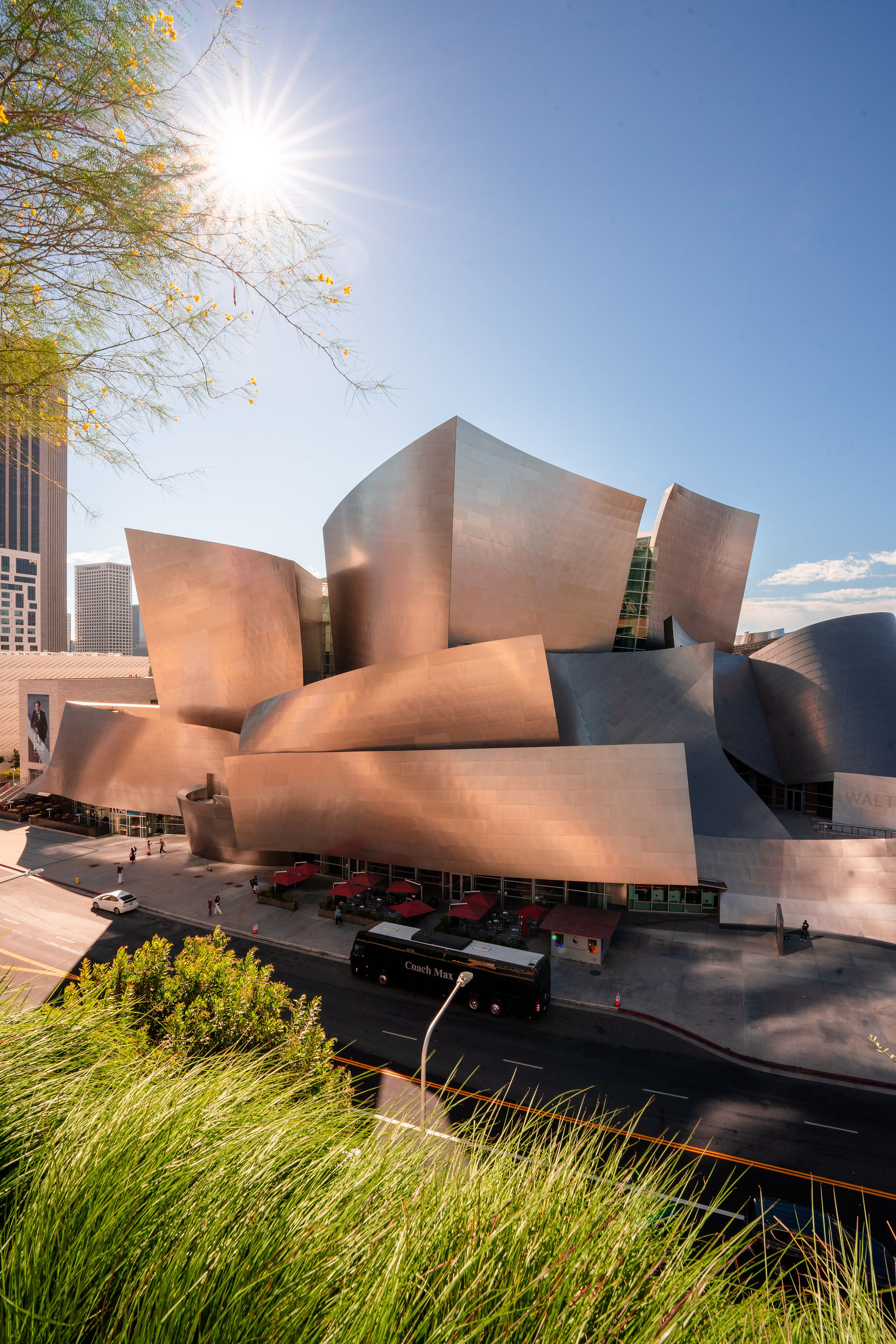 sun illuminating the metal clad building at the disney concert hall