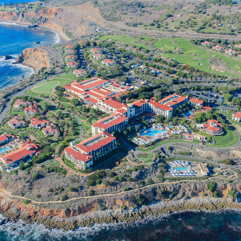 aerial view above looking at the expansive terranea resort property with multiple resort towers, pools, and private villas that sprawl out along the coastal bluffs
