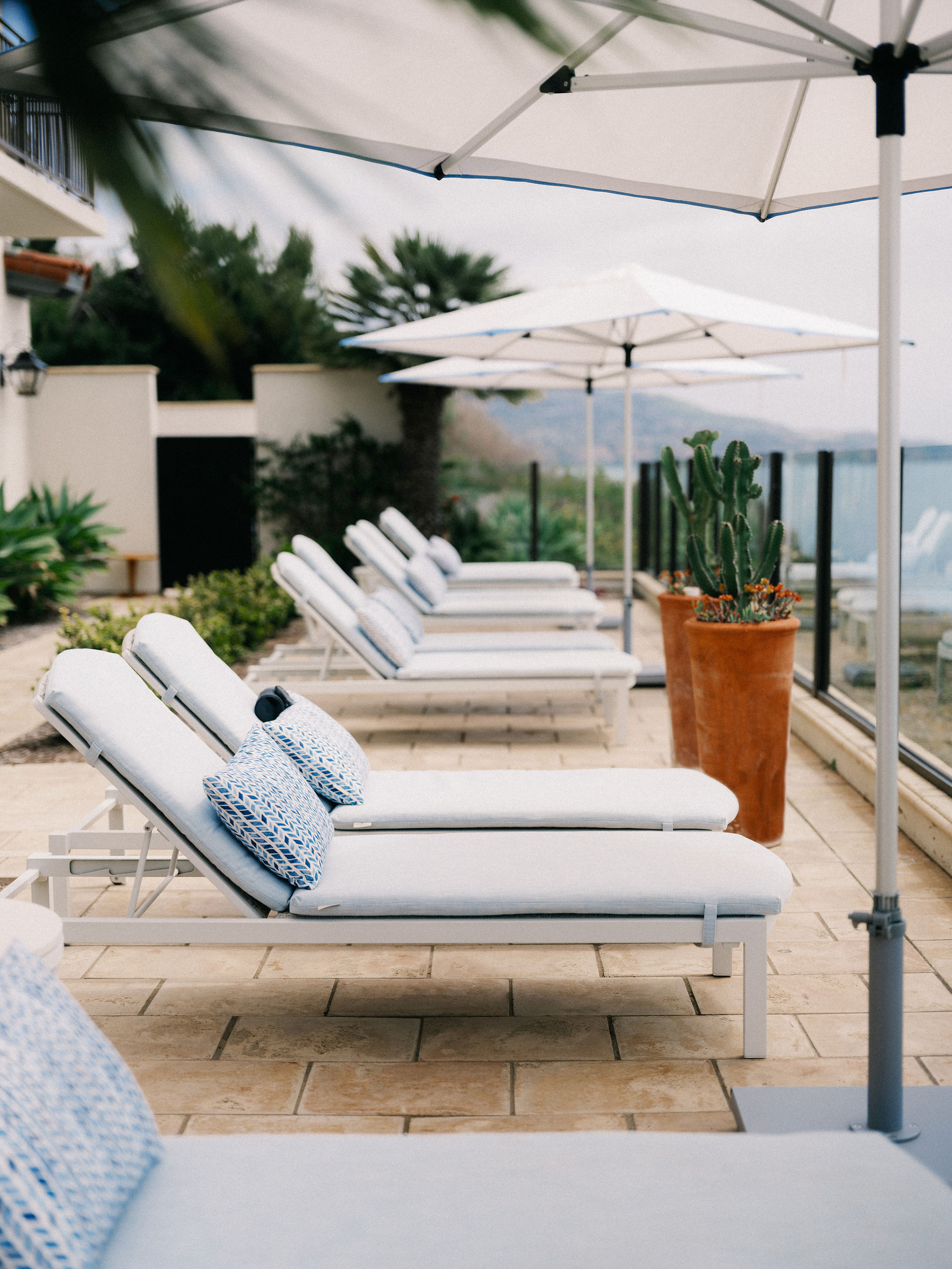 lounge chairs lined along the outside looking out to the ocean 