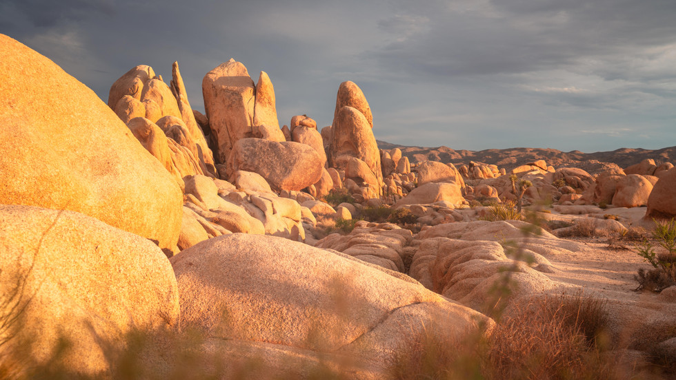 Golden hour light casting on to boulder and rocks in the desert
