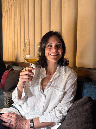 woman in white top holding a large glass of Italian white wine
