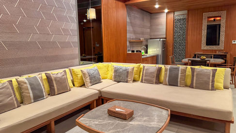 grey and yellow throw pillows on a large oversized tan couch at Sri panwa resort