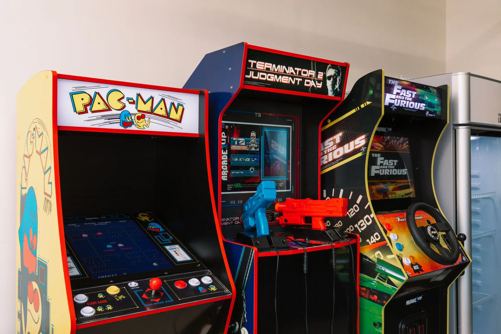 3 arcade games next to each other in a garage home arcade 