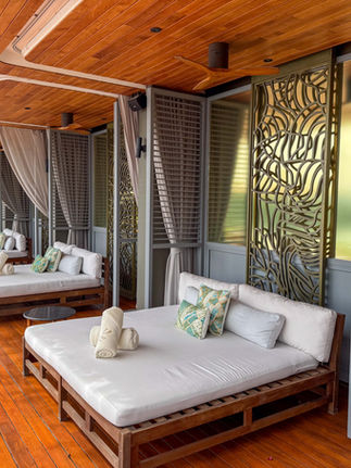 large white two person day bed cabanas with pillow on wood floors and wood ceilings providing elegance and modern design next to the pool