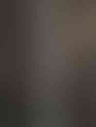 aerial view looking down at a pathway carved out between black lava rocks as a man walks alone