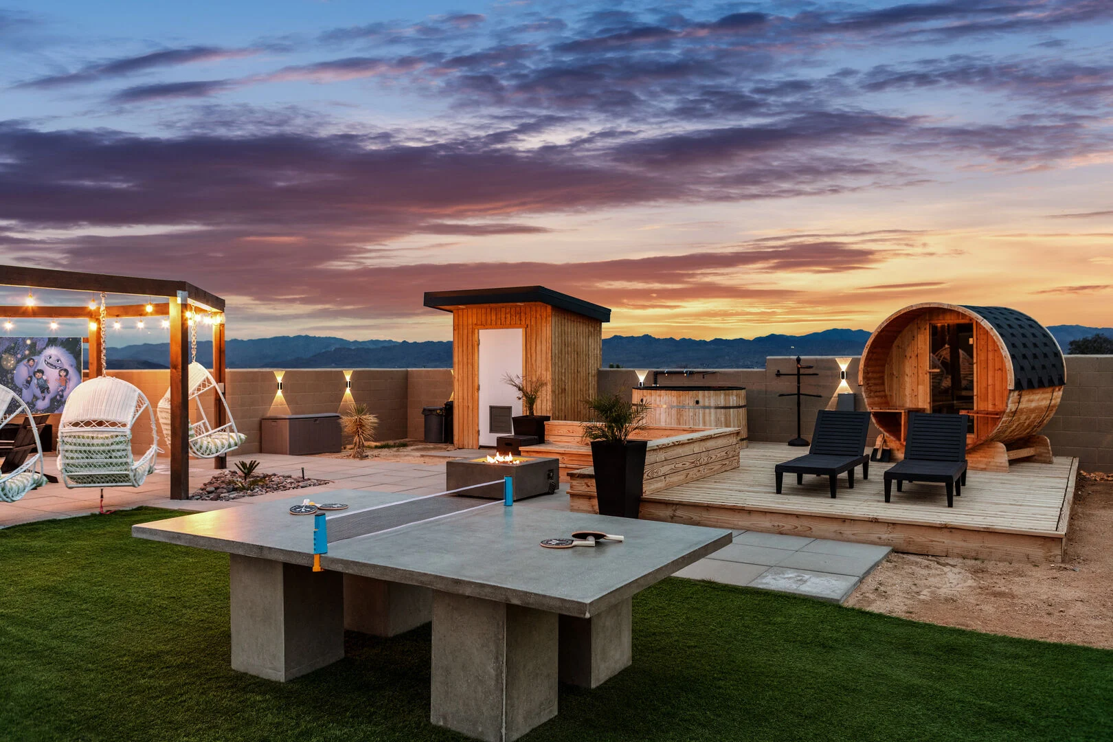 desert vacation rental property outdoor amenities illuminated at night under a sunset sky including  a table tennis and sauna 