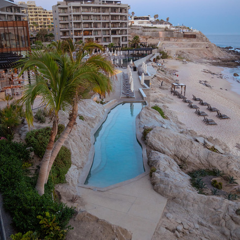 Infinity pool at The Cape Cabo elevated above the beach with lounge chairs and cabanas