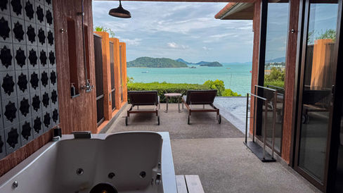 vibrant and tropical blue waters and islands in the distance as seen from an outdoor bathroom with bathtub and shower at Sri Panwa