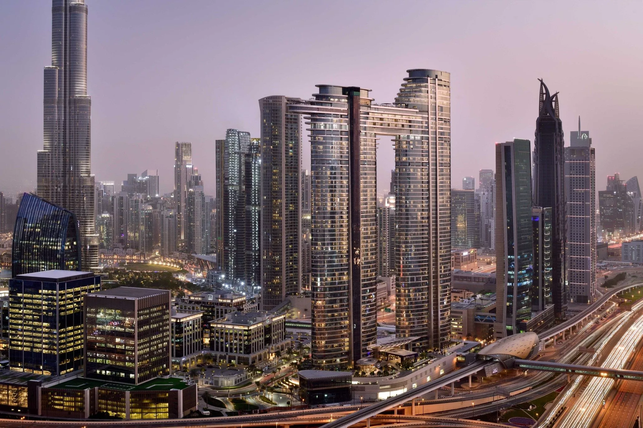 city skyline of Dubai featuring the two tower Address Sky View next to the highway