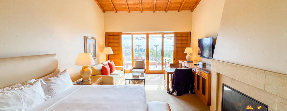 vaulted wooden ceilings in a bridge white room with a king size bed with a fireplace in front of it and classical design and fine wood accents